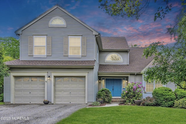 view of front of home featuring a lawn, a garage, a shingled roof, and driveway