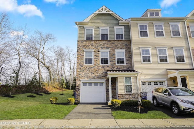 townhome / multi-family property with an attached garage, driveway, a front yard, and stone siding