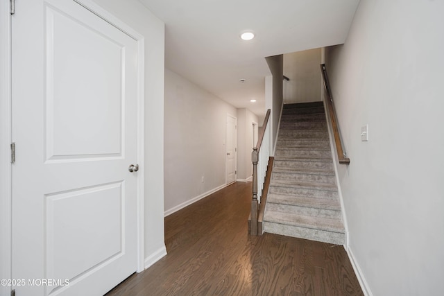 staircase with wood finished floors, baseboards, and recessed lighting