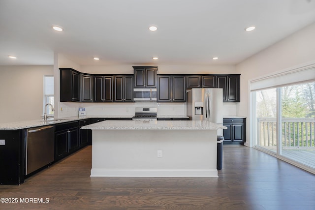 kitchen with a kitchen island, a sink, dark wood finished floors, and stainless steel appliances