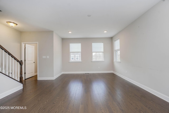 unfurnished living room featuring stairway, recessed lighting, dark wood-type flooring, and baseboards