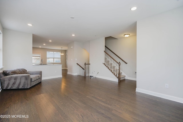 living area with a chandelier, recessed lighting, dark wood-type flooring, and baseboards