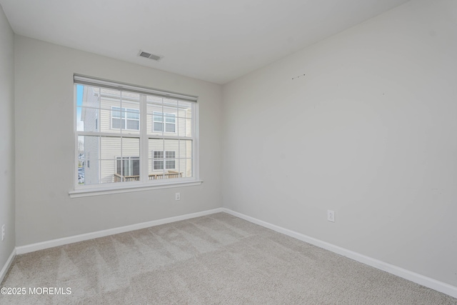 empty room featuring carpet flooring, baseboards, and visible vents