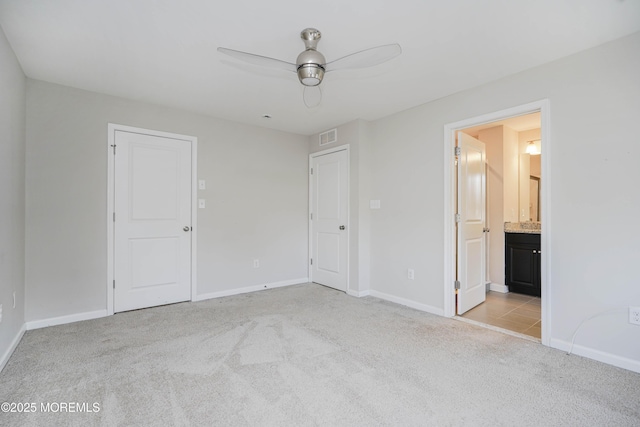 unfurnished bedroom featuring light carpet, baseboards, visible vents, and connected bathroom