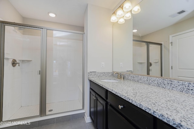 bathroom featuring a shower stall, vanity, tile patterned flooring, and visible vents
