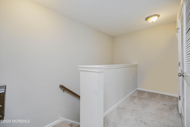 staircase featuring baseboards and carpet floors
