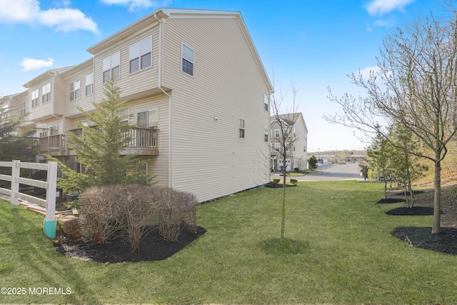 view of side of home featuring a residential view and a lawn