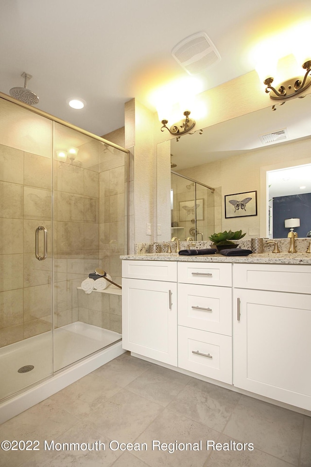 full bathroom featuring visible vents, double vanity, and a stall shower