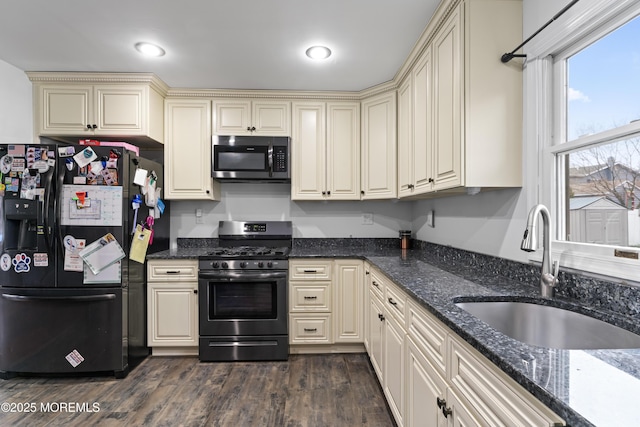 71 6th St, Belford, NJ 07718 - kitchen with cream cabinets, a sink, black fridge, and gas stove