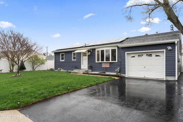 71 6th St, Belford, NJ 07718 - single story home featuring aphalt driveway, fence, a front lawn, solar panels, and a garage