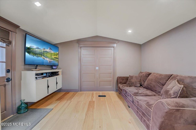 living area with lofted ceiling and light wood finished floors