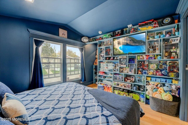 bedroom with wood finished floors and vaulted ceiling