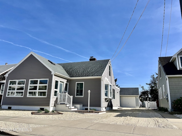 127 8th Ave, Seaside Park, NJ 08752 - view of front of property featuring driveway, a chimney, an outdoor structure, roof with shingles, and a detached garage