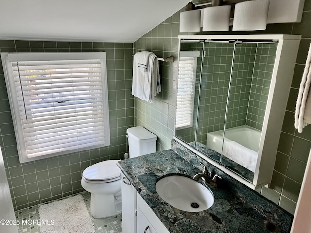 127 8th Ave, Seaside Park, NJ 08752 - full bath featuring tile walls, vanity, toilet, tile patterned floors, and bath / shower combo with glass door