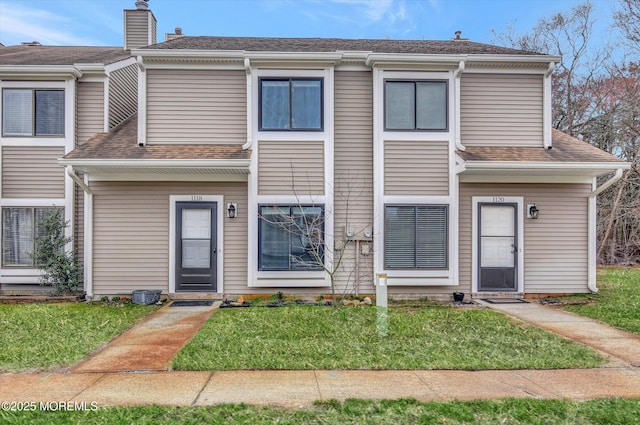 multi unit property featuring roof with shingles and a front lawn