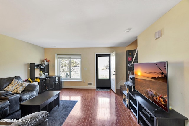 living room featuring visible vents, baseboards, and hardwood / wood-style flooring