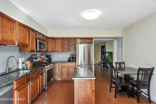 kitchen featuring tasteful backsplash, appliances with stainless steel finishes, dark wood-style flooring, and a sink
