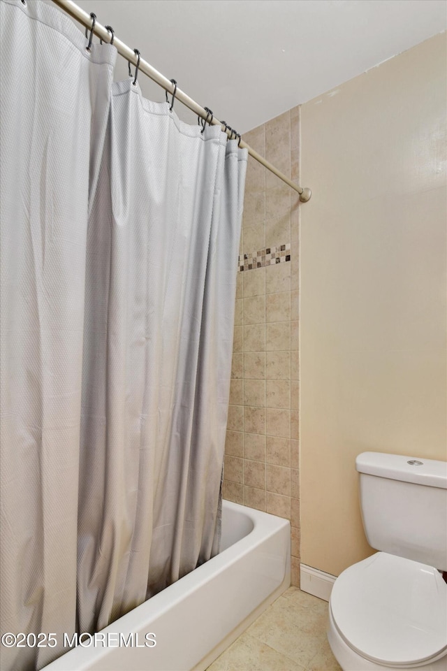bathroom featuring toilet, shower / bathtub combination with curtain, tile patterned flooring, and baseboards