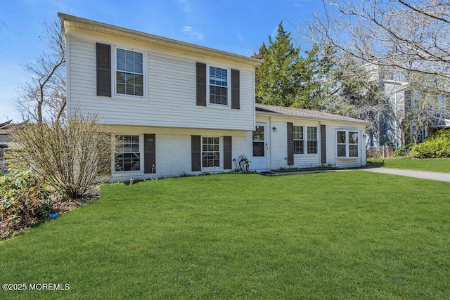 split level home with a front yard and brick siding