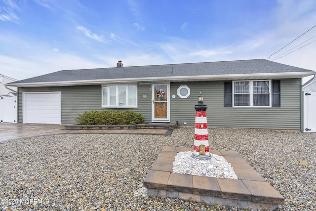 ranch-style house with an attached garage, a shingled roof, and driveway