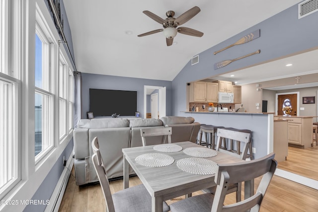 dining area with visible vents, ceiling fan, light wood finished floors, and baseboard heating
