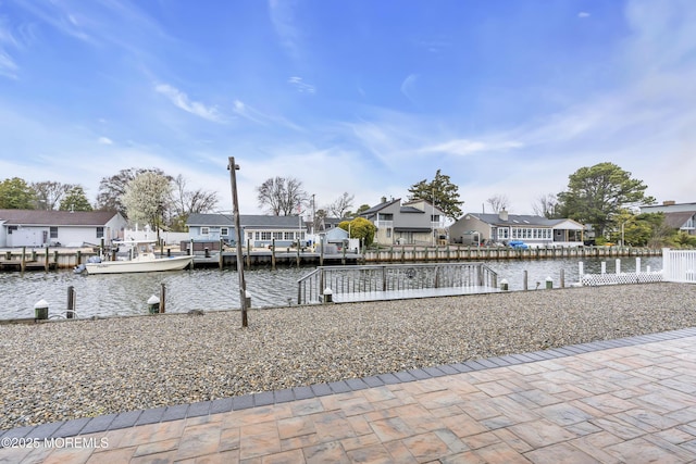 dock area with fence, a residential view, and a water view