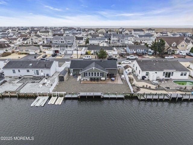 drone / aerial view featuring a water view and a residential view