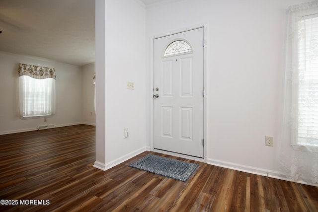 entryway featuring dark wood-type flooring, visible vents, and baseboards