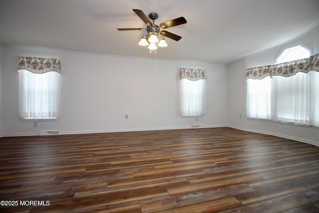 spare room featuring dark wood-type flooring, baseboards, a ceiling fan, and visible vents