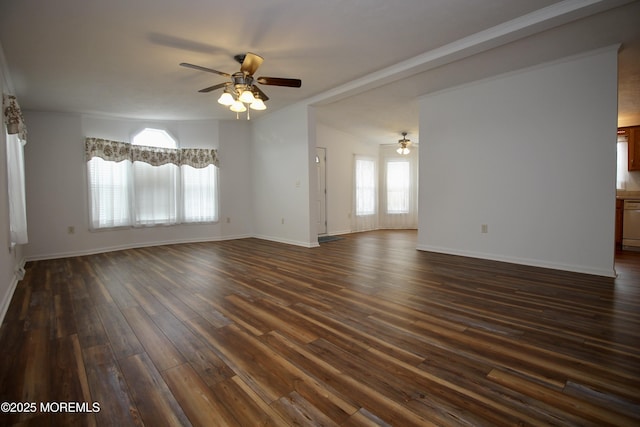 spare room featuring dark wood-type flooring, ceiling fan, and baseboards