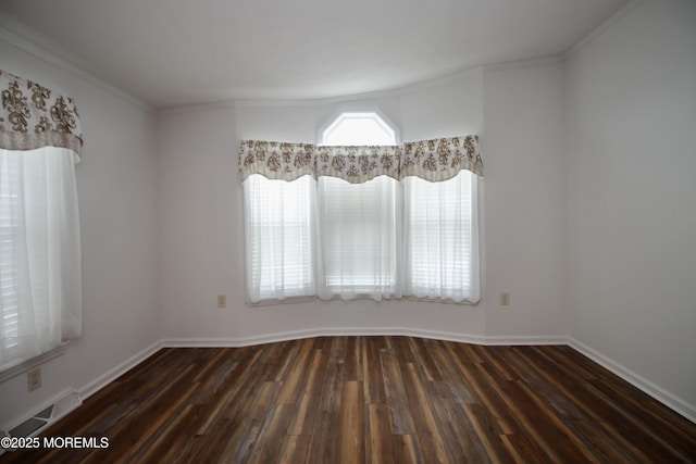 unfurnished room with ornamental molding, visible vents, baseboards, and dark wood finished floors