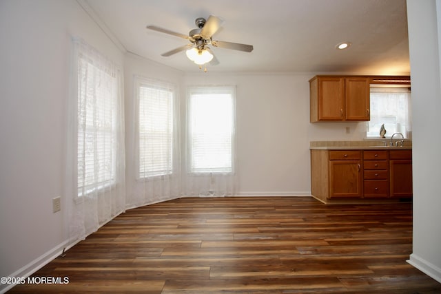 kitchen featuring baseboards, a ceiling fan, dark wood finished floors, brown cabinets, and recessed lighting