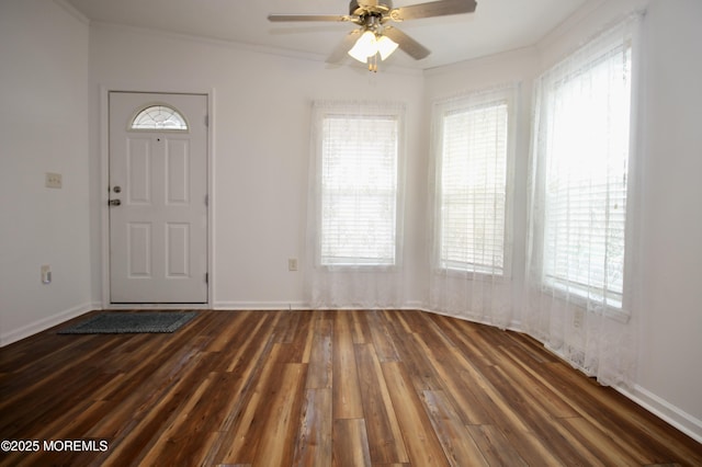 entryway with dark wood-type flooring, ceiling fan, baseboards, and ornamental molding
