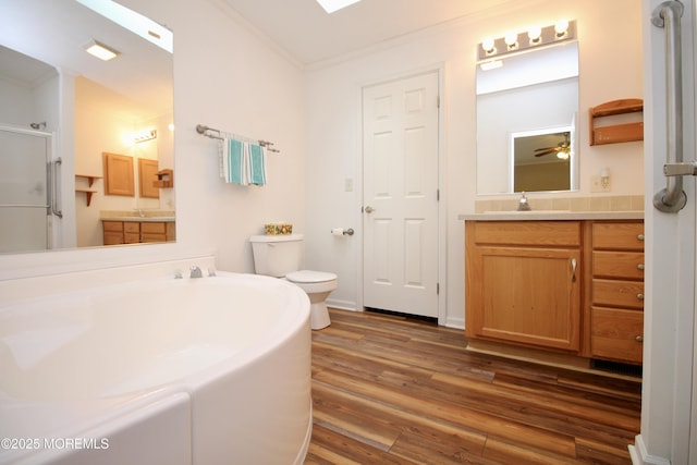 full bathroom with a bath, a sink, ornamental molding, wood finished floors, and a stall shower