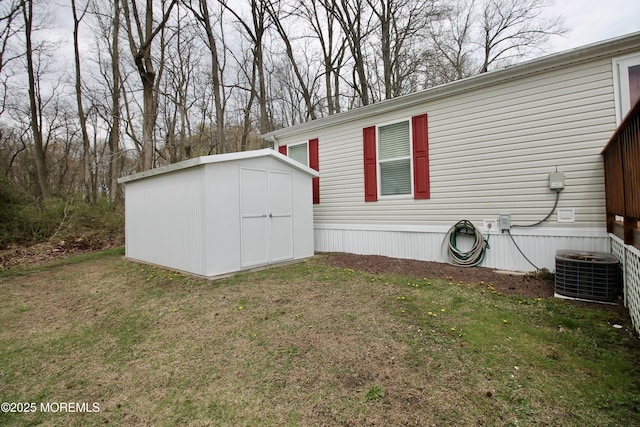 view of side of property with a shed, an outbuilding, central AC, and a lawn
