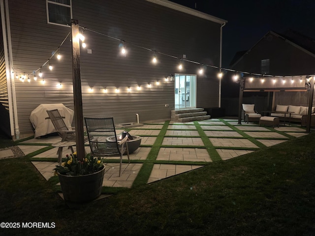 back of house at night with an outdoor hangout area, a patio area, and entry steps