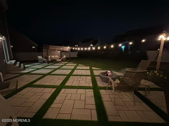 patio at twilight featuring an outdoor living space with a fire pit