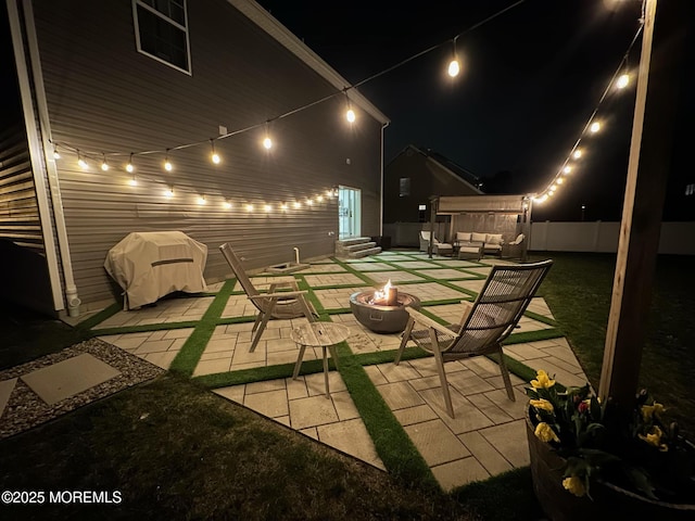 patio at twilight featuring fence, an outdoor living space with a fire pit, and entry steps