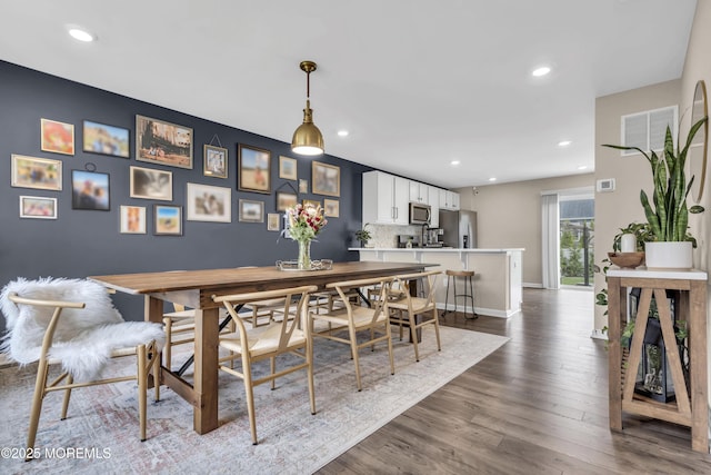 dining space featuring dark wood finished floors, baseboards, and recessed lighting