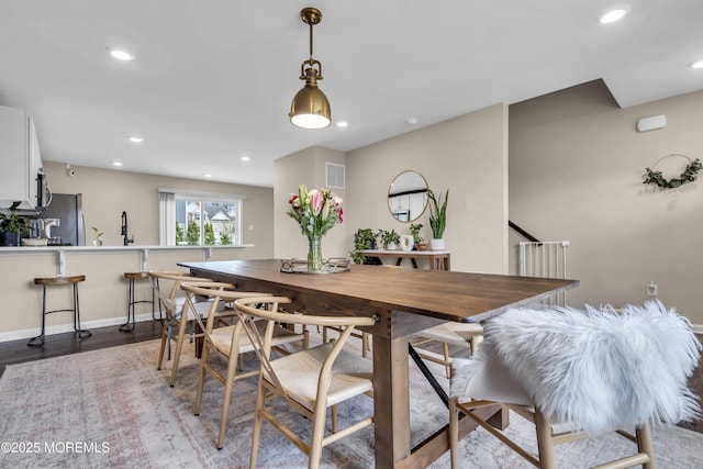 dining space with recessed lighting, wood finished floors, visible vents, and baseboards