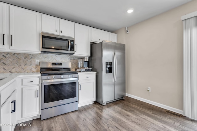 kitchen featuring light countertops, backsplash, visible vents, baseboards, and appliances with stainless steel finishes