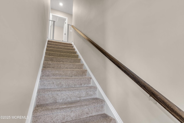 stairs with carpet floors and recessed lighting