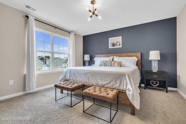 carpeted bedroom featuring baseboards, visible vents, and a chandelier
