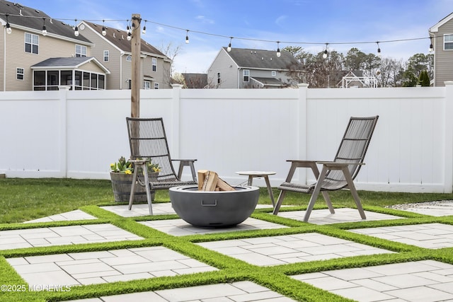 view of yard featuring fence, a fire pit, a residential view, and a patio