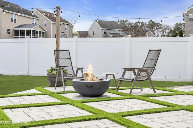 exterior space with a fire pit, fence, a residential view, and a sunroom