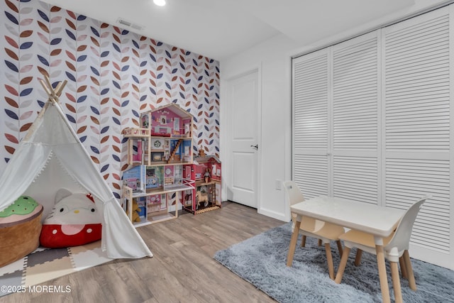 playroom featuring visible vents, baseboards, and wood finished floors