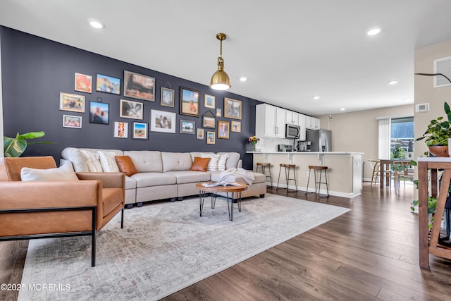 living room featuring recessed lighting, baseboards, and dark wood-style flooring