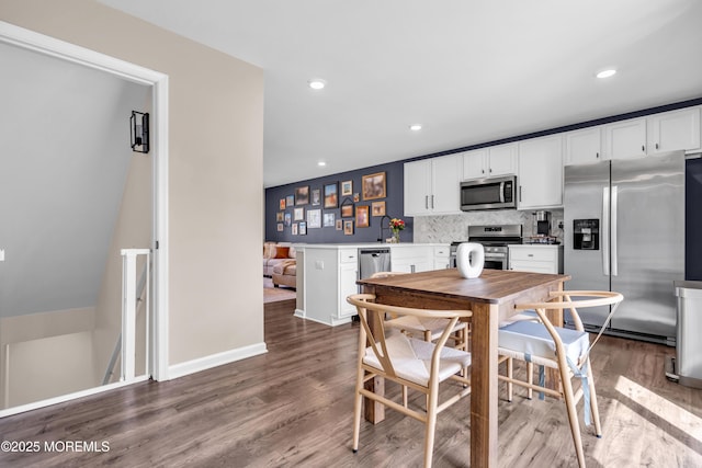 dining space featuring baseboards, wood finished floors, and recessed lighting