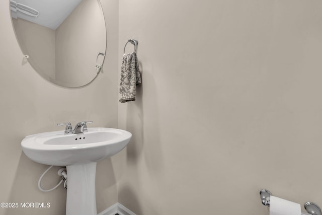 bathroom featuring baseboards and a sink