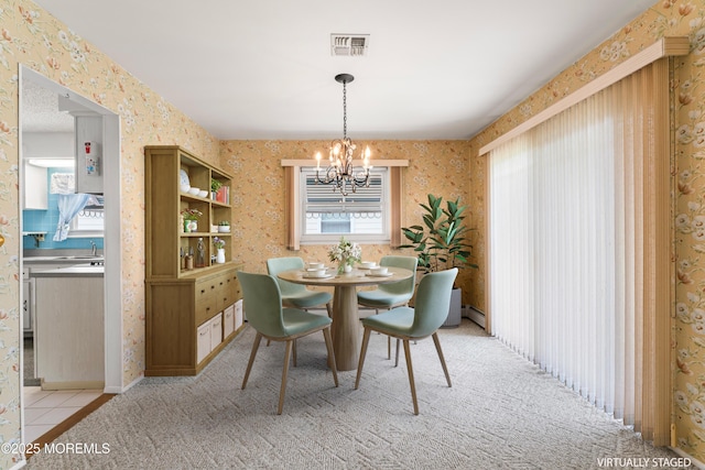 dining room featuring visible vents, a healthy amount of sunlight, a notable chandelier, and wallpapered walls